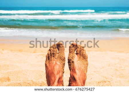 point of view of man's feet in front of the beach