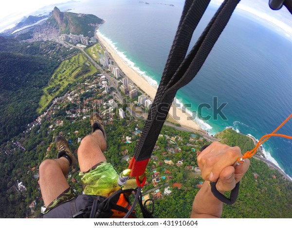 Point of view from paragliding pilot\
over Rio de Janeiro beach, Brazil. Adventure\
concept
