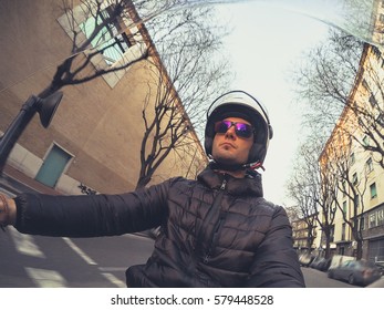 Point Of View Portrait Of A Cheerful Young Adult Man Commuting On A Motorbike In City Traffic.