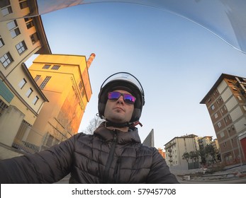 Point Of View Portrait Of A Cheerful Young Adult Man Commuting On A Motorbike In City Traffic.