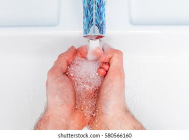 Point Of View Shot Of A Man Washing His Hands In A Bathroom Sink