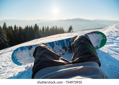 Point Of View Shot Of A Snowboarder Lying On The Snow On The Slope In The Morning, Relaxing After Skiing, Enjoying Stunning View Of Winter Mountains POV Concept