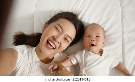 Point Of View, Young Asian Mother And Her Newborn Baby Selfies With Smile Via Video Call Or Facetime Feeling Happy