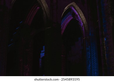 Pointed arch of an old historic brick church with purple and blue lighting at night in Europe  - Powered by Shutterstock