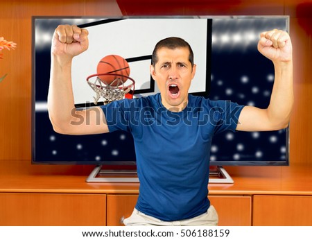 Pointer! Man watching basketball match on television at home and celebrating the triumph
