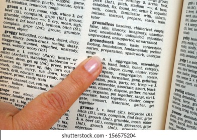 Pointing a finger at words in a thesaurus. - Shutterstock ID 156575204