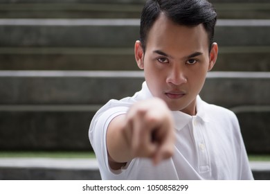 Pointing Man Portrait; Serious Man Pointing Finger Gesture; Asian Man Points At You With Serious Mood Emotion; Young Adult South East Asian Man Model With Tan Skin And Short Hair