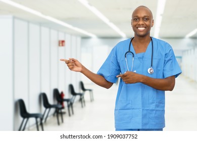 Pointing Mature Adult African American Male Nurse At Vaccination Station For Vacinating Patients Against Coronavirus Infection