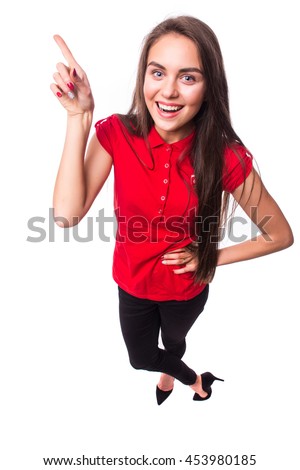 Pointing showing woman. Humorous high angle studio portrait of a grinning woman pointing to the left of the frame with her finger. 