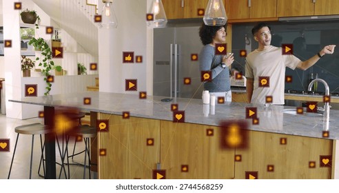 Pointing two men standing behind marble island in kitchen, displaying floating icons, copy space. Friends, casual, openplan, modern, plants, augmentedreality, socialmedia