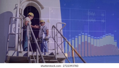 Pointing two techs inspecting access platform at tower, with helmets and harnesses, digital charts. Industrial, safety, maintenance, technician, harness, ladder, turbine