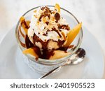 Poire belle Helene, peeled sliced pear poached in syrup served in dessert bowl with vanilla ice cream dressed with chocolate sauce. Popular French dessert..