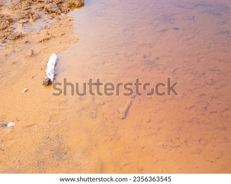 Poisoned mineral water. Red ferric mud of sediments on big boulders, old lignit quarry Babina at Poland German border.