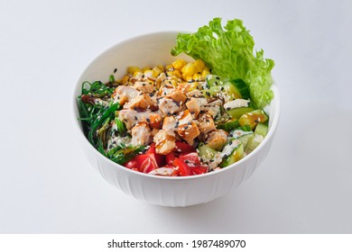 Poke Bowl with chicken, corn, pepper, rice and chukoy. Dish on a white plate.