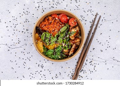 Poke bowl with chicken and vegetables on the white table.