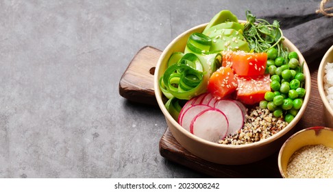 Poke bowl with salmon, cucumber and avocado. Traditional hawaiian meal. With copy space