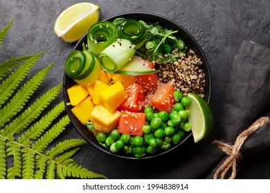 Poke bowl with salmon, cucumber and mango. Traditional hawaiian meal. Top view flat lay