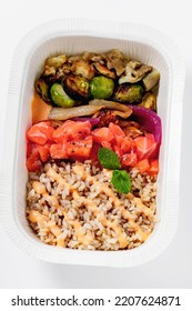 Poke With Brown Rice, Salmon And Grilled Vegetables In A Plastic Takeout Container