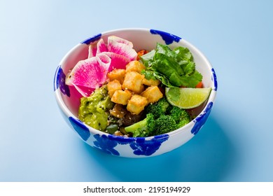 Poke With Tofu, Broccoli, Avocado,edamame,tomatoes,lime,rice On Bowl On Blue Background