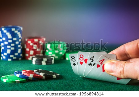 Poker cards with full house or full boat combination. Close up of gambler hand takes playing cards in poker club