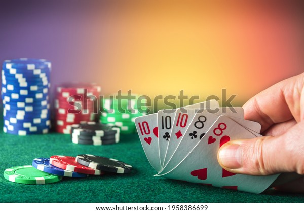 Poker cards with\
full house or full boat combination. Close up of gambler hand takes\
playing cards in poker\
club