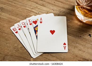 Poker Cards And Whisky Glass On Old Wooden Table.