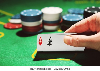 Poker chips and female hand holding cards on green table