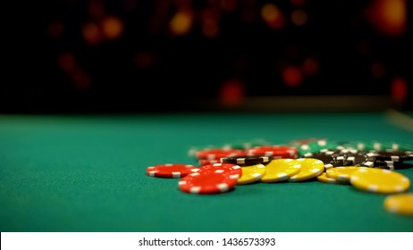 Poker chips lying on green table, poker and blackjack casino games, betting