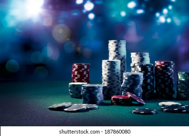 Poker Chips on a gaming table with dramatic lighting - Powered by Shutterstock