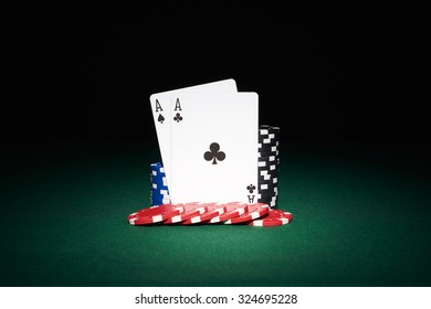 Poker chips on table with aces cards in casino with black background