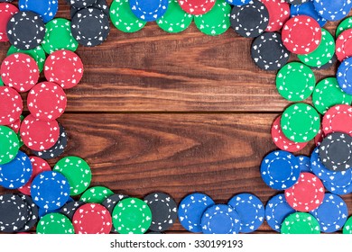 Poker Chips Over Old Wooden Table. Frame Of Poker Chips. Casino Background.