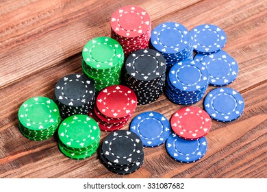 Poker Chips Over Old Wooden Table. Group Of Different Poker Chips. Casino Background.