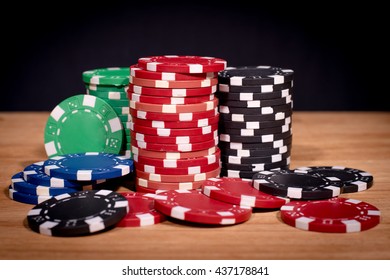 Poker Chips Over Old Wooden Table. Group Of Different Poker Chips. Casino Background.