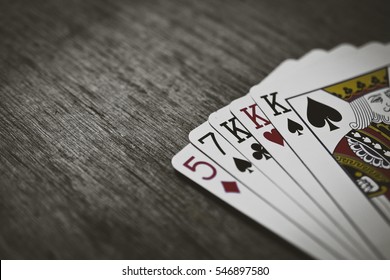 Poker Hands - Three Of A Kind. Closeup view of five playing cards forming the poker three of a kind hand. Texture added. - Shutterstock ID 546897580