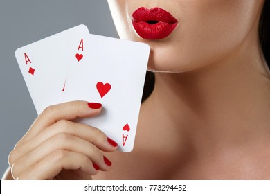 Poker or other card games. Woman with red lips is holding two aces in her hand