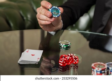 Poker player in the casino with glass of whiskey and cards at the gaming table - Powered by Shutterstock