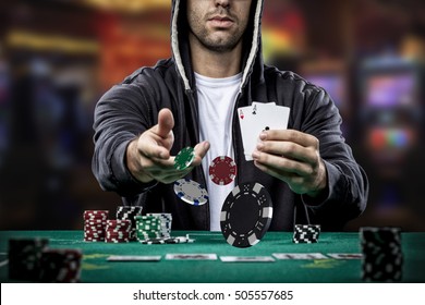 Poker player showing a pair of aces, on a casino background.