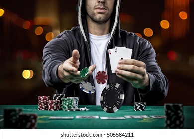 Poker player showing a pair of aces, on a bokeh lights background.