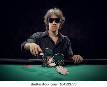 Poker Player At A Poker Table Throwing His Chips