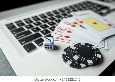 poker playing cards with casino chips on laptop keyboard for online gambling. Top view - Powered by Shutterstock