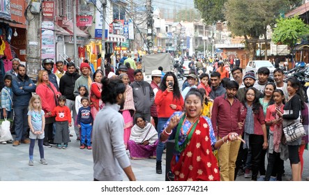 Pokhara city / Nepal - 10 November 2018: Group of different people look at dancing show on the neighbourhood of  Lake Side street, the most popular tourist destination in Pokhara
