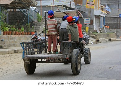 POKHARA, NEPAL - APRIL 2014 : Group of young boy sitting standing on a converted rotary hoe used as Nepali styled mini tractor on street in Pokhara, Nepal on 16 April 2014