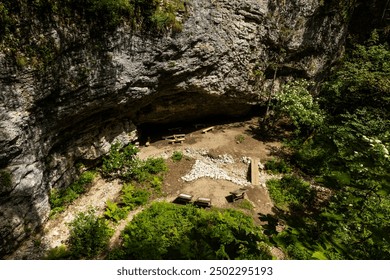 Pokljuka Gorge, Slovenia. Pleasant and relaxing trekking in the forest surrounded by greenery, wooden walkways on the rock, mountain creeks and a huge cave with openings inside where the light passes. - Powered by Shutterstock