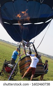 Poland 2019: Flame Hot Air Ballon Started By People On The Ground. Gas Balloning Sport Heating By Instructor And Passengers For Travel.