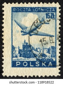 POLAND - CIRCA 1946: Postage Stamp Printed In Poland (Polish Peoples Republic) Shows Douglas Plane Over Ruins Of Warsaw. Scott Catalog C15 AP3 15zt, Blue, Circa 1946