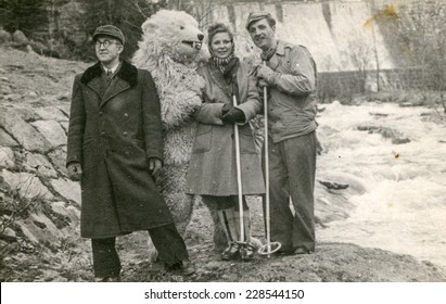 POLAND, CIRCA FIFTIES: Vintage Photo Of Two Men And A Woman Posing With A Fake Bear