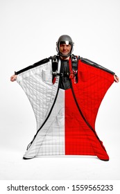 Poland Flag Flying. Bird Men In Wing Suit Flag. Sky Diving Men In Parashute. Patriotism, Men And Flag.
                               