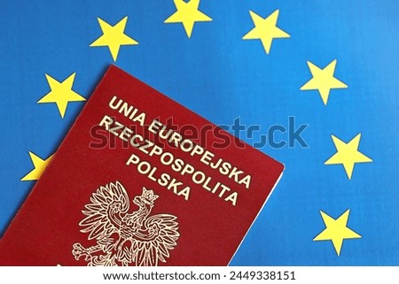 Poland passport of European Union on blue flag background close up. Tourism and citizenship concept