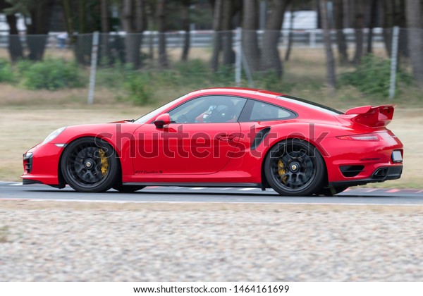 POLAND, POZNAN: July 6, 2019: Red Porsche 911\
Turbo S in motion driving on the\
street