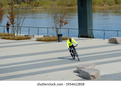 Poland, Warsaw, Vistula Boulevards, April 2021. A Warm Spring Afternoon, A Man On A Sports Bike Rushes Briskly Through Empty Boulevards. In The Background, The River And A Fragment Of The Bridge.